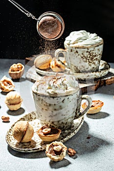 sifting cocoa powder on Cup of tasty cocoa drink, vertical image. top view. place for text