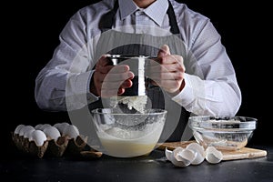 Sifting flour in bowl. man cooking dessert concept