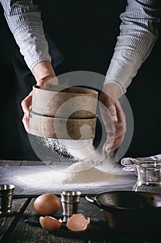 Sifting flour by female hands