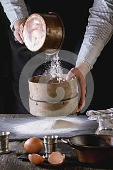 Sifting flour by female hands