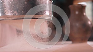 Sifting flour. female hands gently sift flour on the table