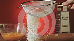 Sifting flour through sieve slow motion