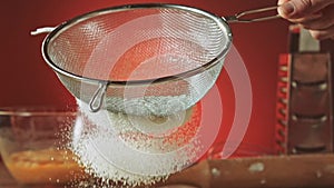 Sifting flour through sieve slow motion