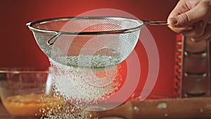 Sifting flour through sieve, slow motion 240fps. Baker sifting measured flour on a table, Cooking and backing