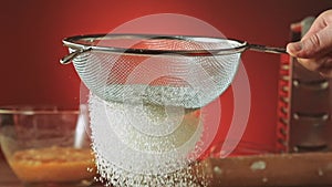 Sifting flour through sieve, slow motion 240fps. Baker sifting measured flour on a table. Cooking and backing