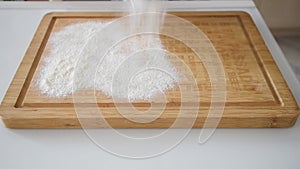 Sifting flour on a wooden board