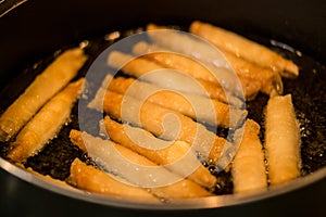 Sigara Boregi / Turkish Cigar Shaped Rolls frying in a pan.