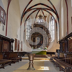 Sighisoara, Romania - July 2, 2019: Interior of the Church of the Dominican Monastery in Sighisoara. The bronze baptismal font