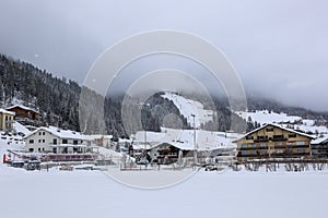 Sight to the foggy, snowy Landscape, Skiing Slope and the Houses of Churwalden, Switzerland in Wintertime