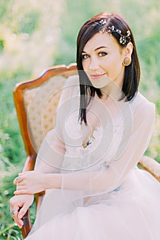 The sight of the woman in spring white dress, with hair accessories and the tattoos on her chest and stomach, sitting on