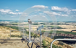 Vyhlídkový dalekohled a slovenská krajina s poli a mraky