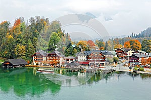 A sightseeing boat cruising on Konigssee  King`s Lake  surrounded by colorful autumn trees