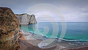 Sightseeing view to the wonderful cliffs of Etretat washed by the waves of the blue sea water, La Manche Channel. Famous Falaise d