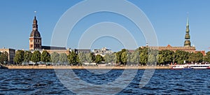 Sightseeings of Riga from the river Daugava. View of the Dome Cathedral, St. Peter`s Church and the promenade