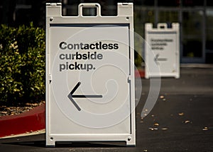 Sign advertising Contactless Curbside Pickup at retail store parking lot