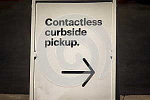 Sign advertising Contactless Curbside Pickup at retail store parking lot