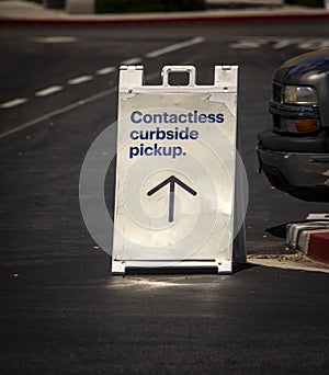 Sign advertising Contactless Curbside Pickup at retail store parking lot