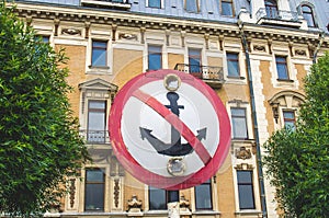 Sign anchor mooring on the background of an ancient building.