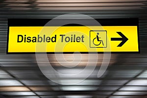 sign with arrow point to disabled toilet at the airport