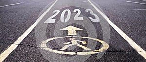 A sign on the asphalt for pedestrians only, with the numbers 2023, a New Year's banner template. The concept of a