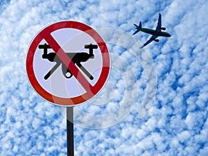 Sign ban drones on sky background with clouds and taking off plane.