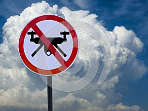 Sign banning drones on sky and clouds background.