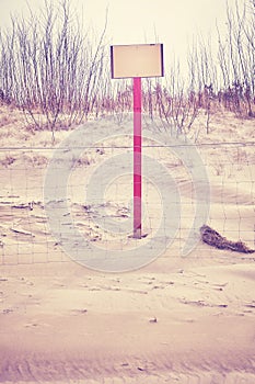 Sign on beach dune with space for text.