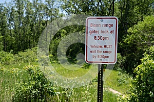 Sign - Bison range gates lock, vehicles must exit in the evening - at Minneopa State Park in Mankato Minnesota photo