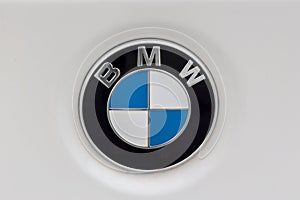 Sign of a BMW logo on white car.