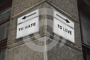 Sign boards with different directions - TO HATE or TO LOVE on building outdoors