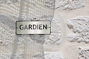 Sign on building outdoor gardien means guardian concierge service in french