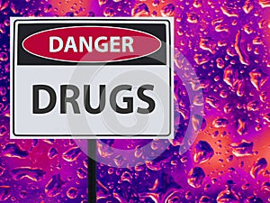 Sign danger drugs and neon drop on the glass.