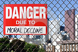 Sign danger due to moral decline hanging on the fence