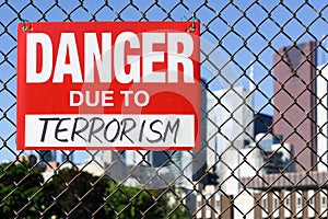 Sign danger due to terrorism hanging on the fence