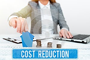 Sign displaying Cost Reduction. Business overview process of finding and removing unwarranted expenses Discussing House