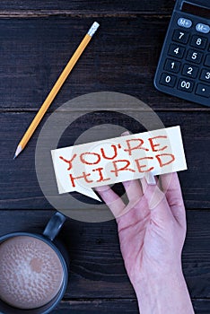 Sign displaying You Re Are Hired. Internet Concept New Job Employed Newbie Enlisted Accepted Recruited Woman Hand With