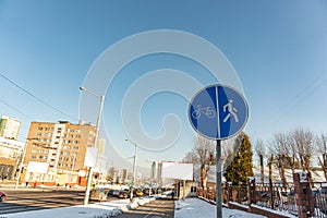 A sign that divides the path for pedestrians and bicyclists. Round blue sign Pedestrian and Bicycle path close-up