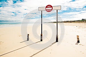 A sign do not enter, standing on the wide beach