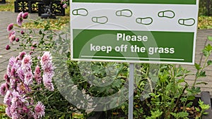 Sign Do Not Walk On The Grass on with pink flowers. No Sign Of Trampling The Lawn