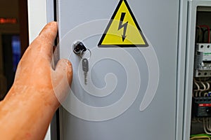 The sign on the door gently with electricity and hand in glove dielectric opens the door photo