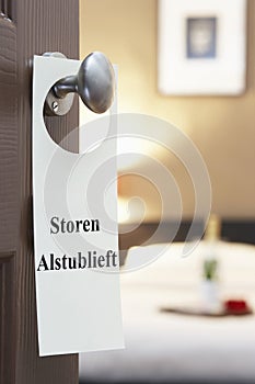 Sign with Dutch text Storen Alstublieft (please disturb) hanging on hotel room door