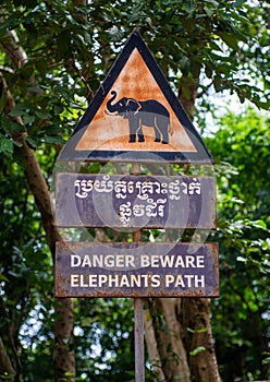 Sign of elephant crossing, danger beware elephant\'s path, cambodia, triangle and double language sign.