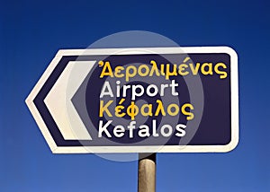A sign in English and Greek directing tourists to The Airport