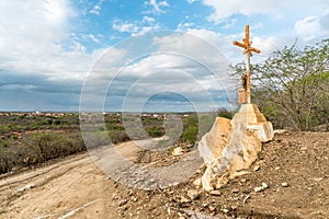 A sign of faith, a cross, beautiful clouds in a dry road at Cariri Paraiba Brazil Countryside photo