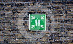 Sign for a fire assembly point installed on a brick wall photo