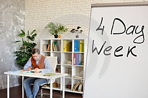 Sign Four day week for work in the office on whiteboard.