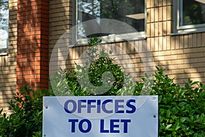 A sign in front of some offices stating offices to let