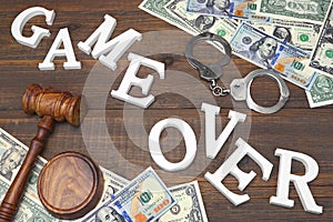 Sign Game Over, Money, Handcuffs, Judges Gavel On Wood Background