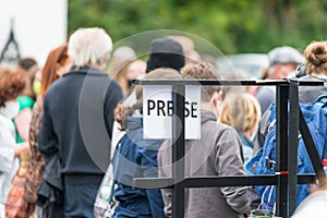 Sign with German word Presse in English Press in front of waiting crowd at rally