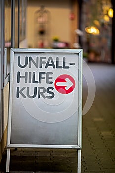 Sign with guide to the first aid class, text in german language Unfall Hilfe Kurs, translated first aid class photo